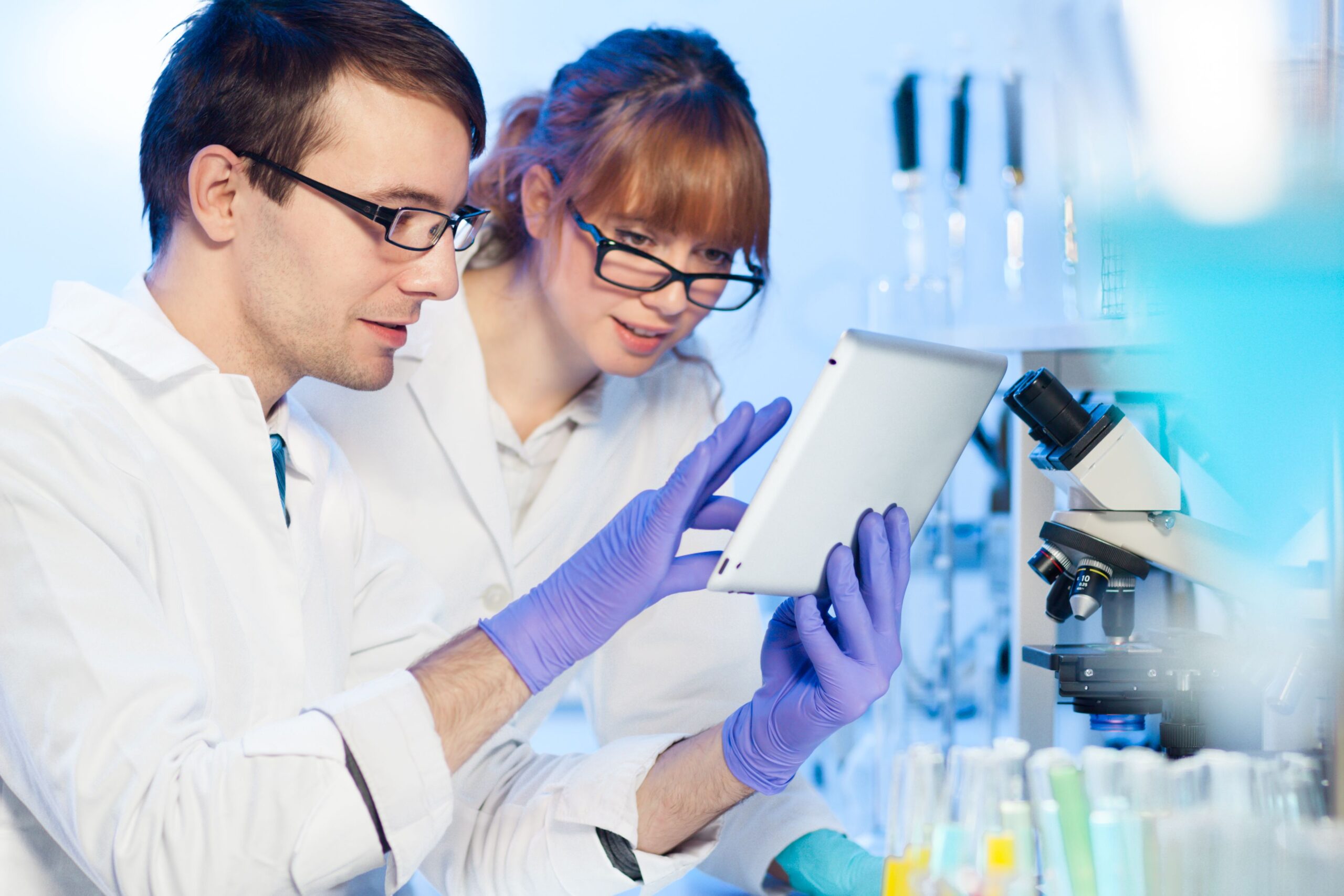 Male and Female Researchers Examining Tablet in Lab